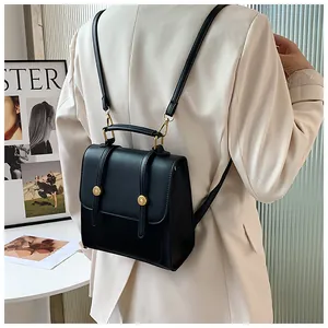 Détail d'un sac à dos rétro en cuir noir avec boucles dorées porté par un mannequin