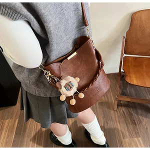 Braune Leder-Eimertasche mit Webgriff und süßem Löwen-Plüsch-Detail