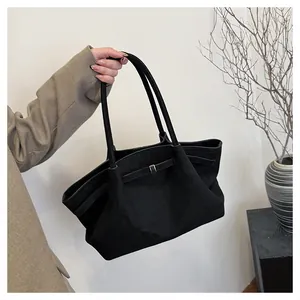 Dettaglio della borsa tote in pelle scamosciata nera con fibbia in metallo e texture