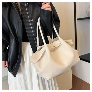 Dettaglio della grande borsa tote crema con texture morbida e fibbia in metallo dorato