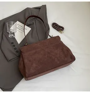 Dettaglio borsa vintage marrone opaco con tracolla regolabile e finiture in bronzo