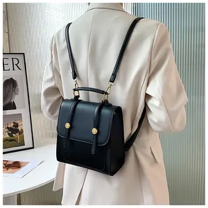 Détail du mini sac à dos en cuir PU noir avec finitions dorées porté sur un blazer beige