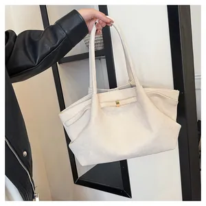 Dettaglio della borsa tote in tela bianco avorio con fibbia dorata e design pieghettato