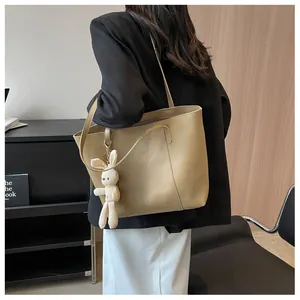 Detailed side view of an apricot large capacity tote bag with a cute rabbit plush pendant