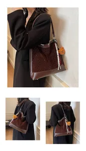 Detail of dark brown suede tote bag with silver studs, plush bear charm and striped scarf