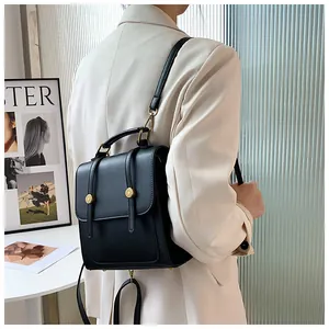Détail du sac à dos en cuir noir vintage montrant les bretelles et boucles dorées