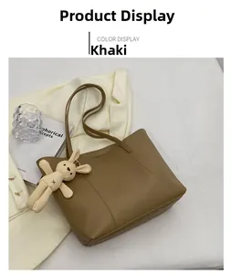 Close-up of khaki faux leather tote bag with a cute beige rabbit plush keychain