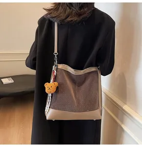 Rear view of brown suede polka dot tote bag with leather strap and cute bear charm