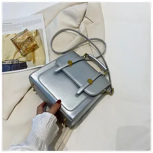 Détail du sac à main argenté métallisé avec boucles dorées et bandoulière fine
