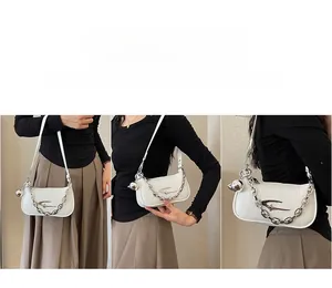 Detail of white pleated leather bag with silver chain and star metal logo ornament