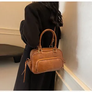 Detail of vintage caramel brown leather bag with matte gold hardware and adjustable strap