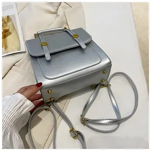 Vue détaillée du fond d'un sac argenté avec pieds de protection et fermoir doré chic