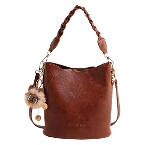 Retro braune Eimertasche mit geflochtenem Griff, Gold-Beschlägen und Bärenanhänger