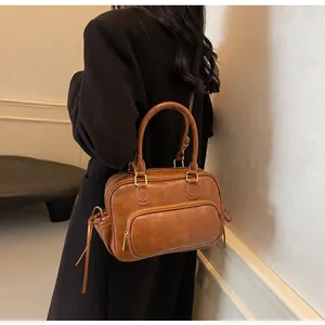 Close-up of caramel brown retro Boston bag with premium synthetic leather texture