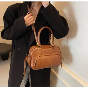Macro view of brown vintage PU leather handbag with side drawstrings and gold hardware