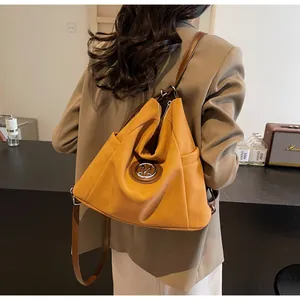 Detailansicht des senfgelben Rucksacks mit Leder-M-Logo und Vintage-Stil