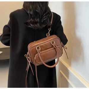 Rear view of model wearing a vintage dark brown leather bowling bag with side tassels