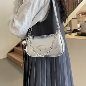 Futuristic silver metallic shoulder bag with chunky chain strap and star emblem