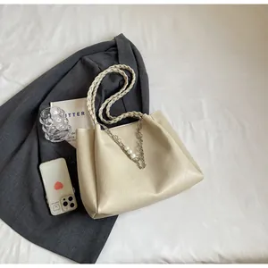 Detail view of cream tote bag with woven handle, pearl charms and silver chain