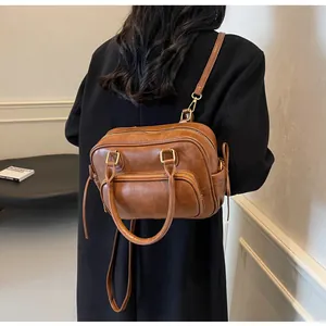 Detail view of a vintage brown leather multi-pocket backpack worn with a dark winter coat