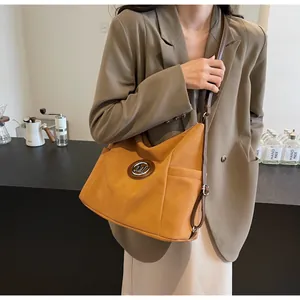 Detail einer gelben Vintage Hobo-Tasche mit Metall-M-Logo und verstellbarem Schultergurt