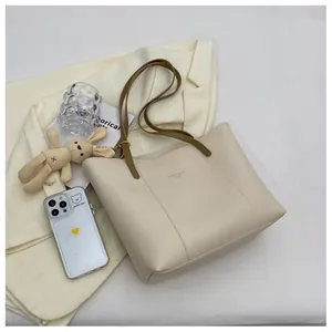 Detail of cream white tote bag with long brown straps and elegant textured PU leather finish