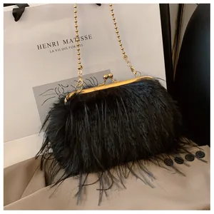 Detail of elegant black feather clutch bag featuring a gold clasp and delicate bead chain