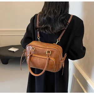 Detail of vintage brown leather backpack worn with black blazer for a commute look