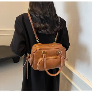 Detail of vintage brown leather backpack showing high-quality gold hardware and straps