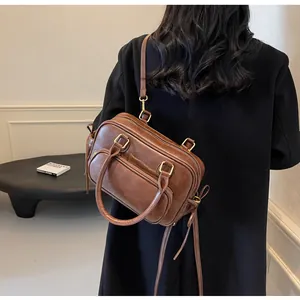 Model wearing a retro brown bowling backpack featuring multi-pocket design and matte leather