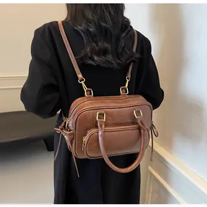 Detail view of a vintage dark brown leather backpack on a model wearing a black coat