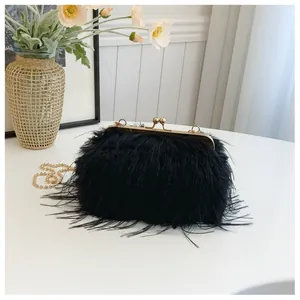 Detailed close-up of fluffy black feather evening bag with golden bead chain strap