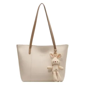 Minimalist beige tote bag with brown straps and cute bunny charm for women's daily commute