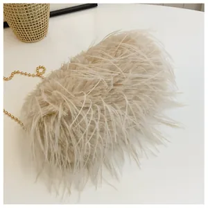 Detail of elegant cream faux fur evening bag with polished gold ball chain strap