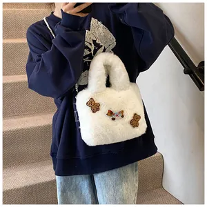 Detail einer weißen Plüschtasche mit niedlichen Cartoon-Bären und Welpen-Stickereien