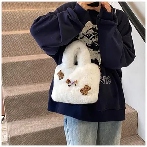 Detailaufnahme der weißen Plüsch-Beuteltasche mit süßen Bären- und Hunde-Stickereien