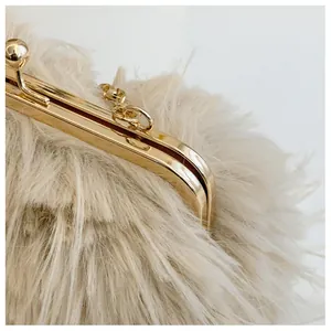 Detail of beige faux fur handbag showing soft texture and gold metal clasp closure