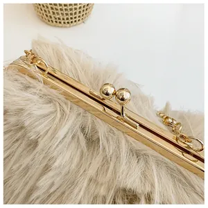 Close-up of fluffy faux fur handbag with golden metal frame and round ball clasp