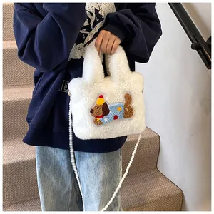 Detail einer weißen Plüsch-Eimertasche mit Hunde-Stickerei und Perlenketten-Riemen