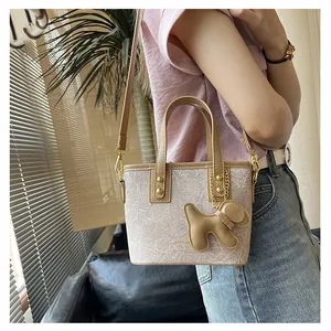 Detail der minimalistischen Beuteltasche mit strukturiertem Stoff und kleinem Hundeanhänger