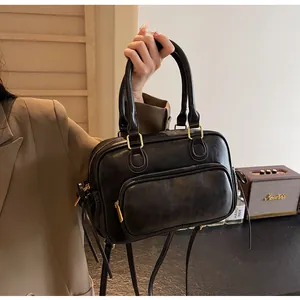 Detail of vintage black PU leather handbag with gold hardware and zipper pocket