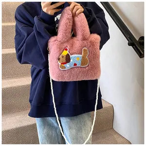 Detailansicht der rosa Kunstfell-Beuteltasche mit niedlicher Cartoon-Hundestickerei