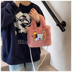 Detail der pinken Plüsch-Beuteltasche mit Hunde-Stickerei und Perlen-Schultergurt
