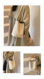 Macro detail of beige bucket bag showing litchi grain texture and printed fashion text