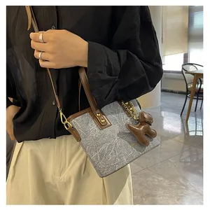 Detail der Handtasche mit grauem Marmormuster, Hundeanhaenger und braunem Schultergurt