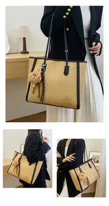 Large sand yellow suede tote bag with black leather straps and plush charm detail