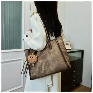 Detail of vintage tote bag with marble texture and plush lion charm on model