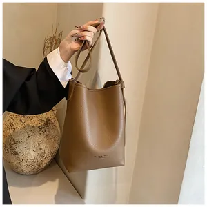 Close-up of brown litchi textured bucket bag showing soft leather material and stitching