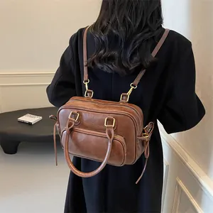 Vintage brown leather backpack for women with gold hardware shown on a model