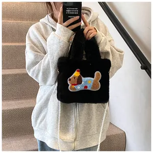 Detail der schwarzen Plüsch-Eimertasche mit Hunde-Stickerei und Perlenketten-Riemen